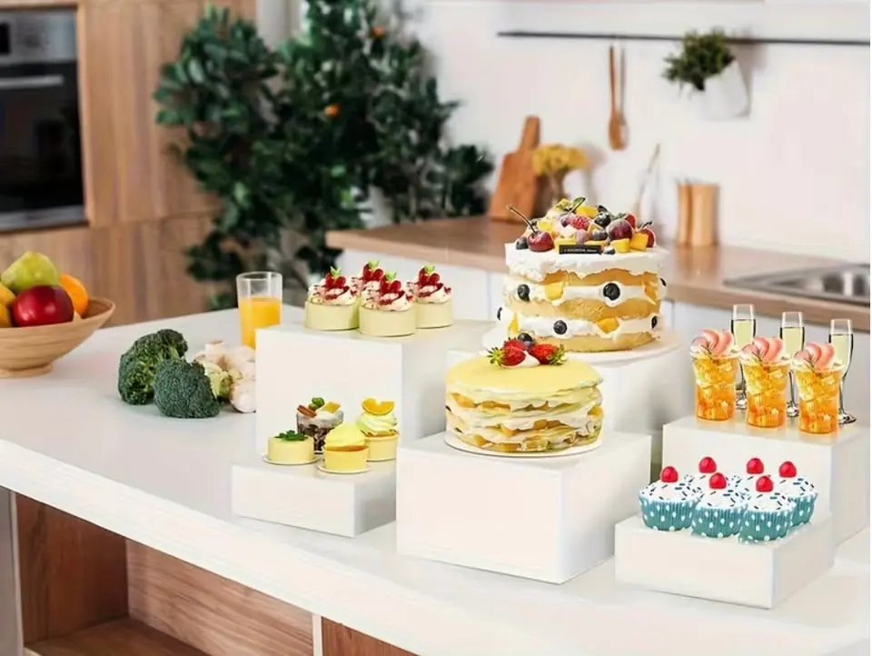 Set of 6 white acrylic buffet risers in graduated heights — a great way to elevate dessert tables, appetizers, welcome tables, and event displays. Perfect for weddings, bridal showers, baby showers, parties, and catered events. This set includes six heights: 3, 4, 5, 6, 7, and 8 inches.