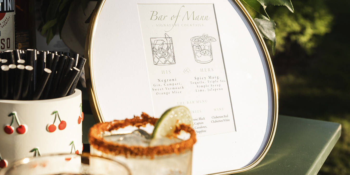 Bar of Mann cocktail setup with elegant signage and custom drinkware