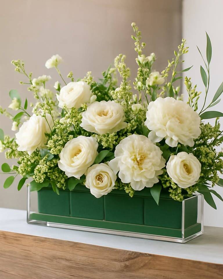 Large rectangular acrylic vase designed for substantial floral or greenery arrangements. The clear acrylic creates a modern, clean aesthetic and makes stems and water visible for an organic, deconstructed look. A versatile standalone centerpiece for guest tables.
