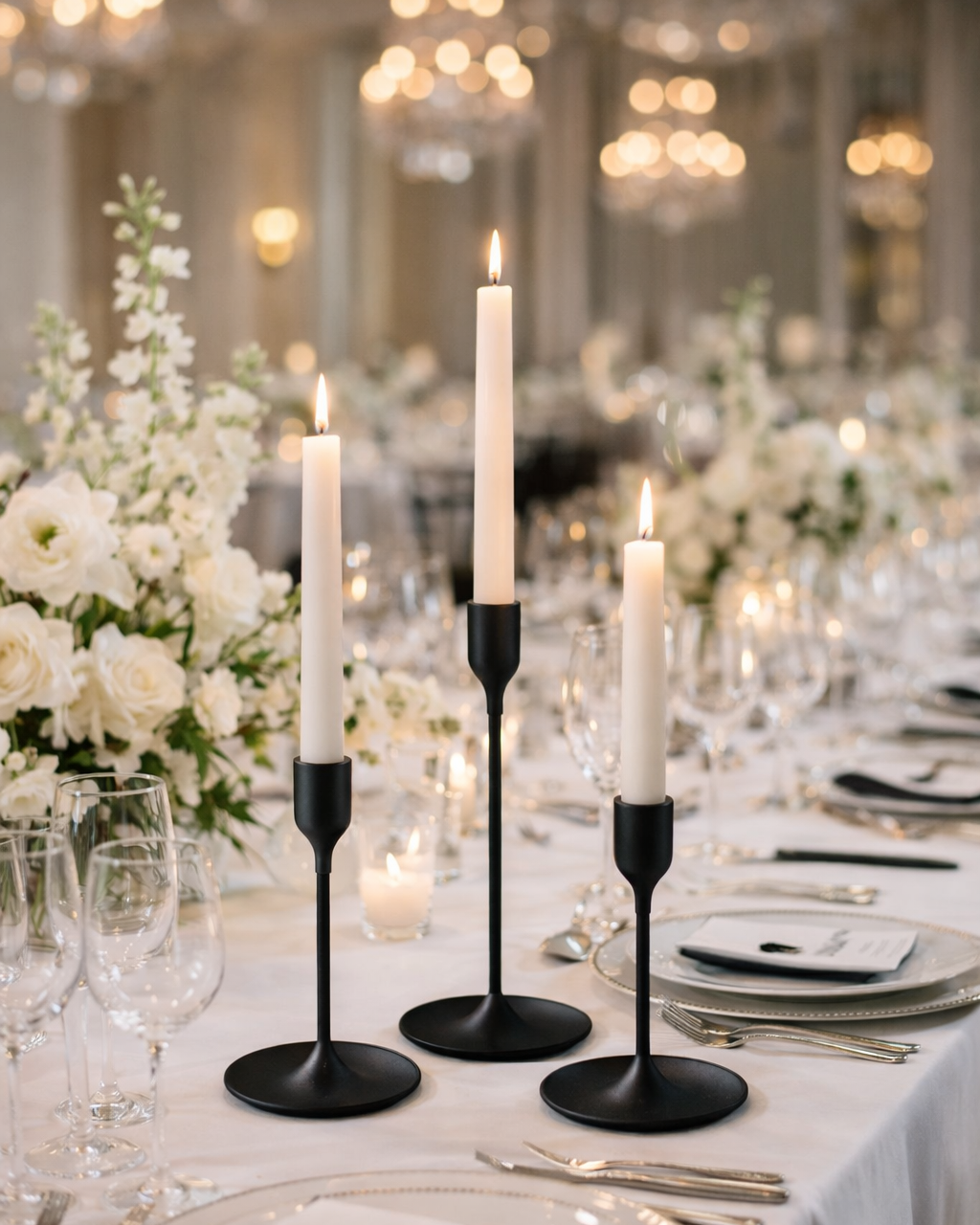 Set of three matte black taper candle holders in graduated heights. The dark finish creates dramatic contrast on white tablecloths and adds a modern, moody edge to tablescapes. Perfect for couples who want something bold and unconventional.