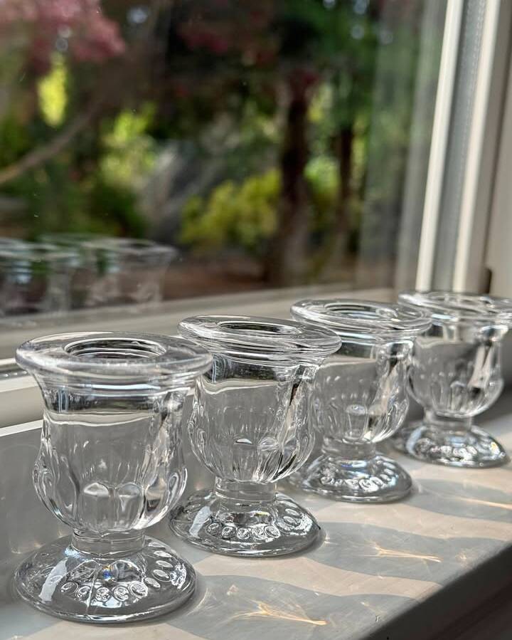 Classic clear glass taper candlestick holder that adds elegant height to tablescapes. The transparent glass catches and refracts candlelight for a luminous effect. Mix with our other candle holder styles for a layered, organic look.