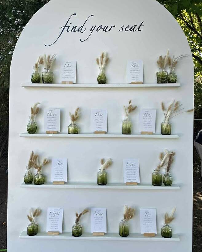 Versatile 8-foot white display wall featuring 4 built-in shelves. Perfect for dessert tables, escort card displays, welcome areas, and favour stations. The clean, modern design works with any colour palette and photographs beautifully. Freestanding construction compatible with all venue types.