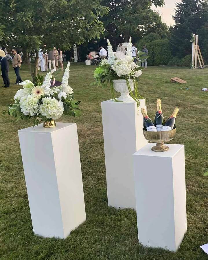 Our tallest display plinth at 42 inches. Creates commanding height for floral arrangements, ceremony aisle decor, and cake displays. The clean white finish complements any style from rustic to modern. Group with our 36-inch and 30-inch plinths for graduated visual impact.