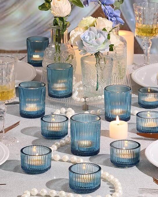 A curated set of 10 assorted blue candle holders in varying sizes, shapes, and blue tones. Designed to be scattered across a tablescape for a collected, artful look. Perfect for waterfront weddings and coastal-inspired celebrations.