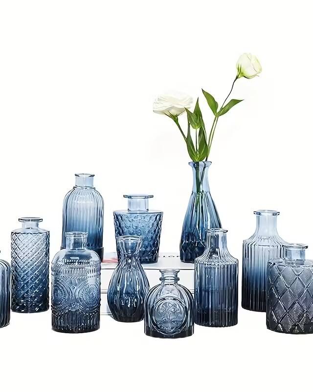 A box of 12 mini blue glass bud vases for single stems and small sprigs. The cool blue tone evokes lakeside and coastal settings, making them ideal for Okanagan waterfront weddings and ocean-themed celebrations.