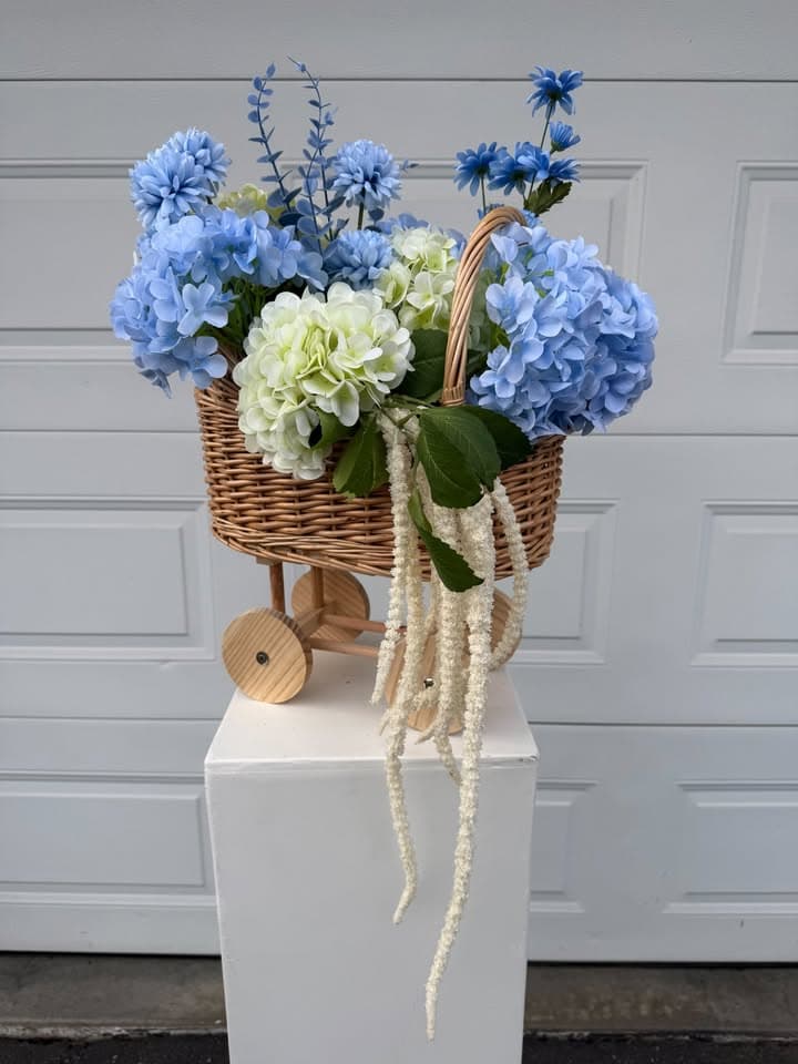 A beautiful faux floral arrangement styled in a stroller — a charming statement piece perfect for baby showers, gender reveals, and children's events. Colours can be adjusted to suit a neutral palette or soft pink to match your event theme.