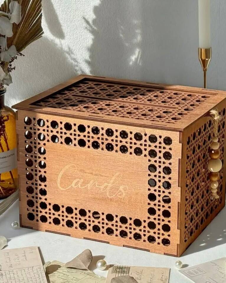 Charming wooden card box with bohemian styling. Features a slot for cards and envelopes with a secure closure. The natural wood finish adds warmth and rustic character to your gift table. Pairs beautifully with our guestbook sign and display plinths.